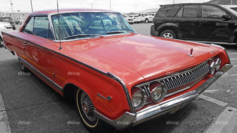 A Classic Orange Mercury Marauder on display in a parking lot