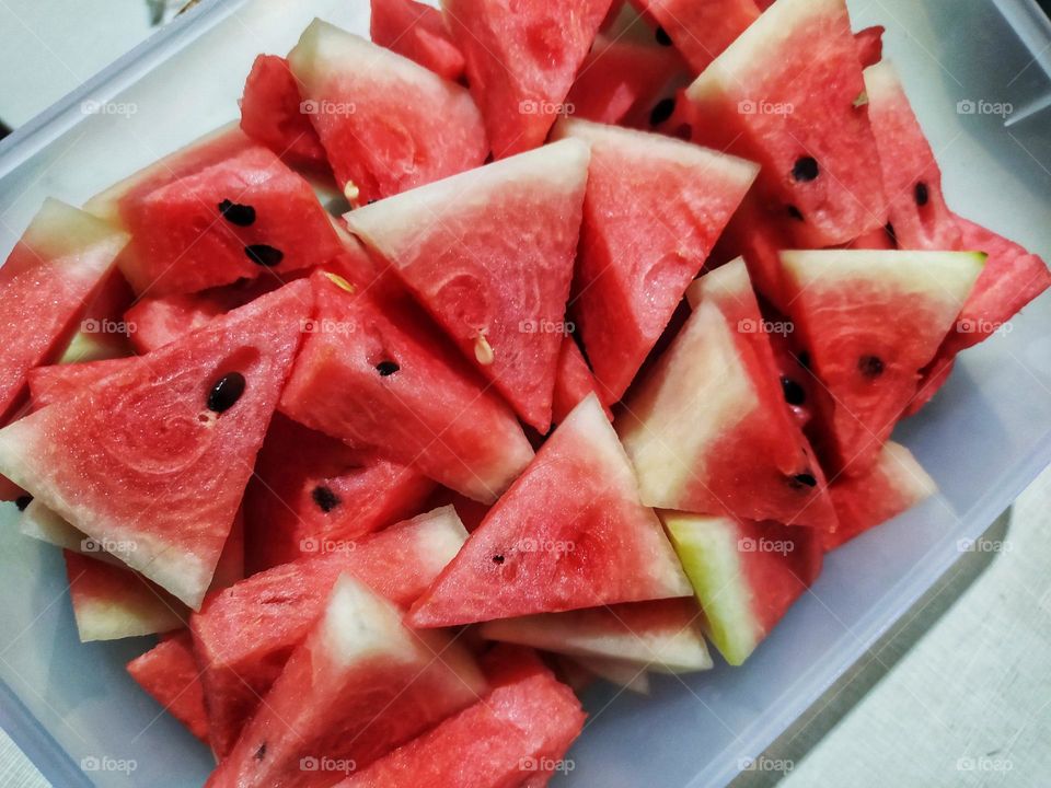 Pile of watermelon pieces in a triangular shape ready to eat