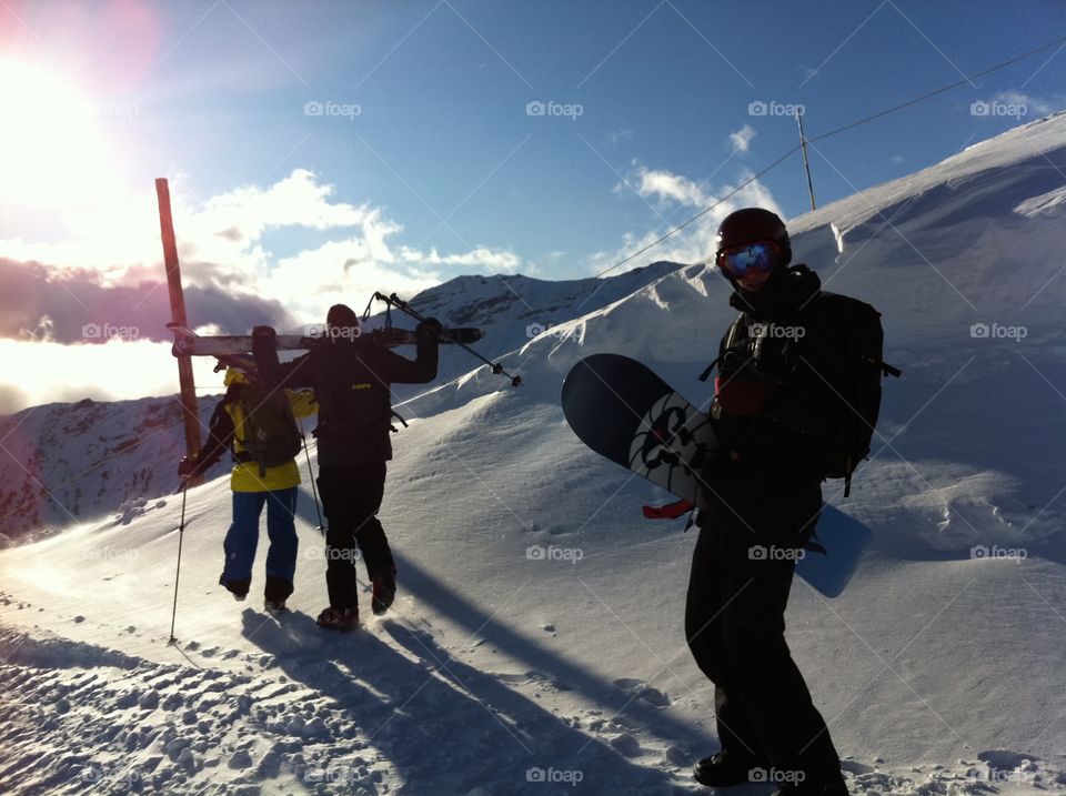 Freeride snwboarding with friends in the french Alps mountains. Beautiful sun light.