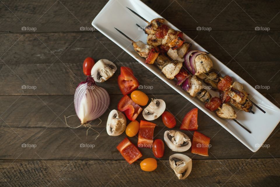 Kabobs and ingredients on wood