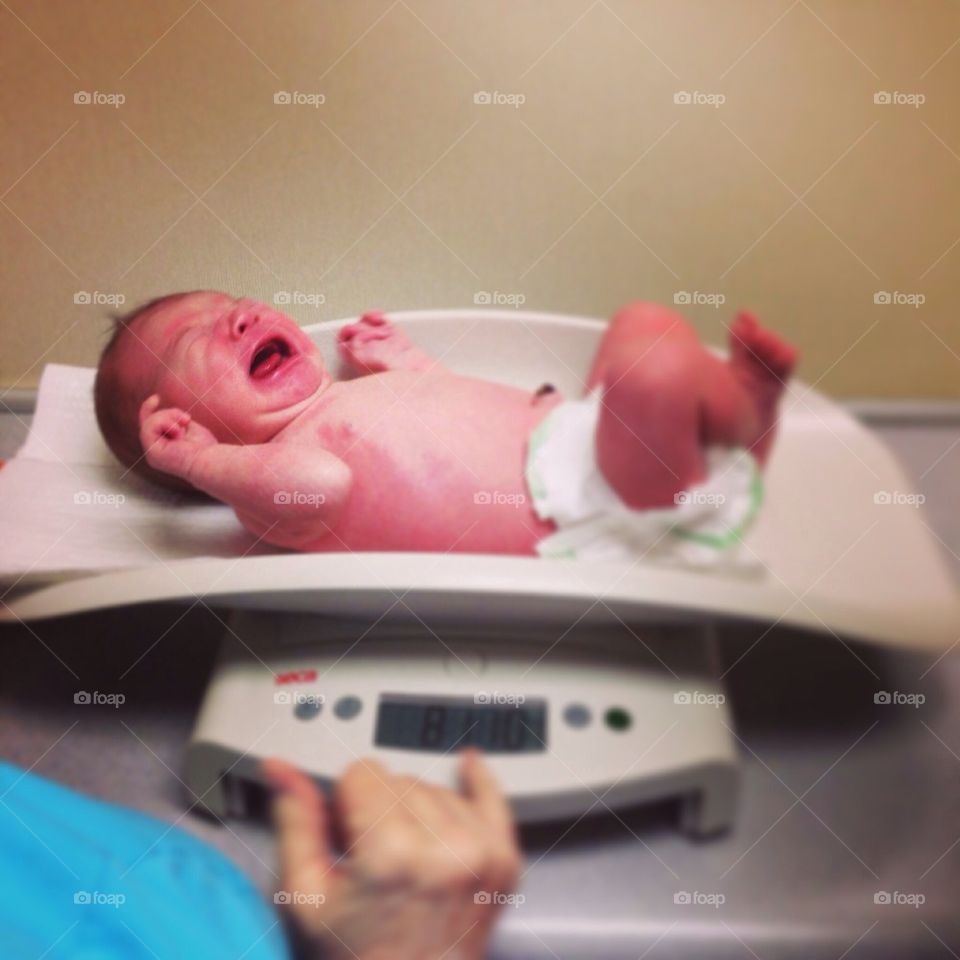 Weighing newborn (who is not happy)