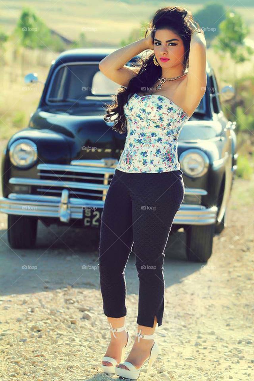 Beautiful woman posing in front of vintage car