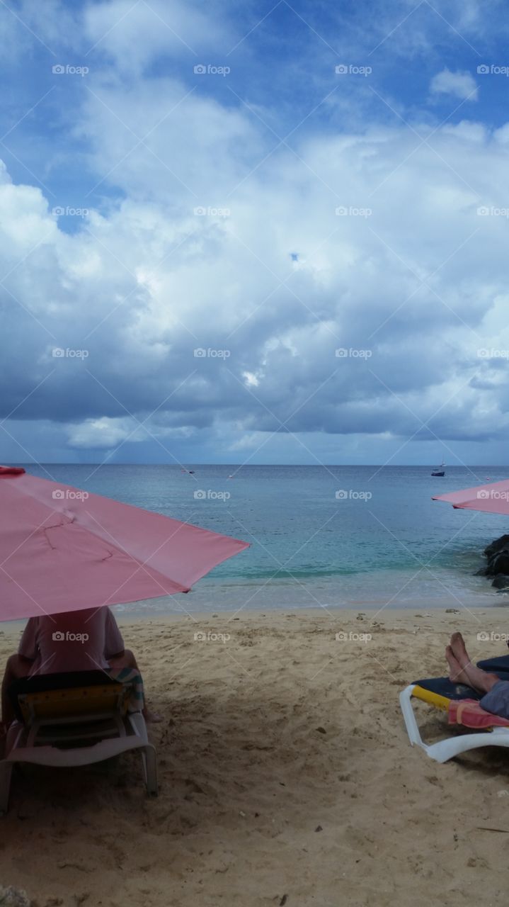 People hanging out on the beach on a calm day in Barbados.