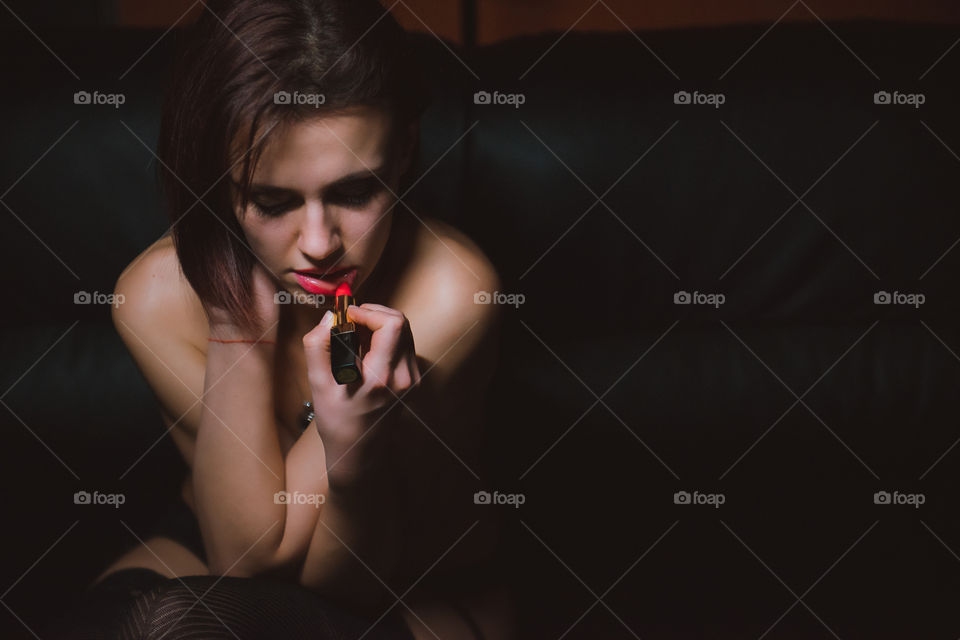 Beautiful woman sitting against black background