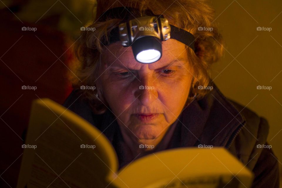 My mother reads a book with a helm lamp