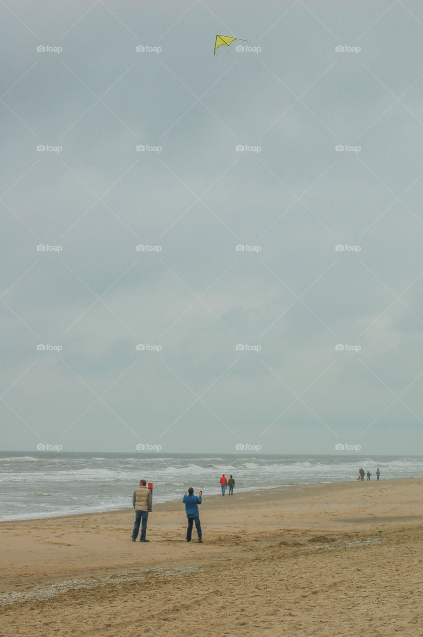 People At The Beach Of Texel The Netherlands Playing With A Kite