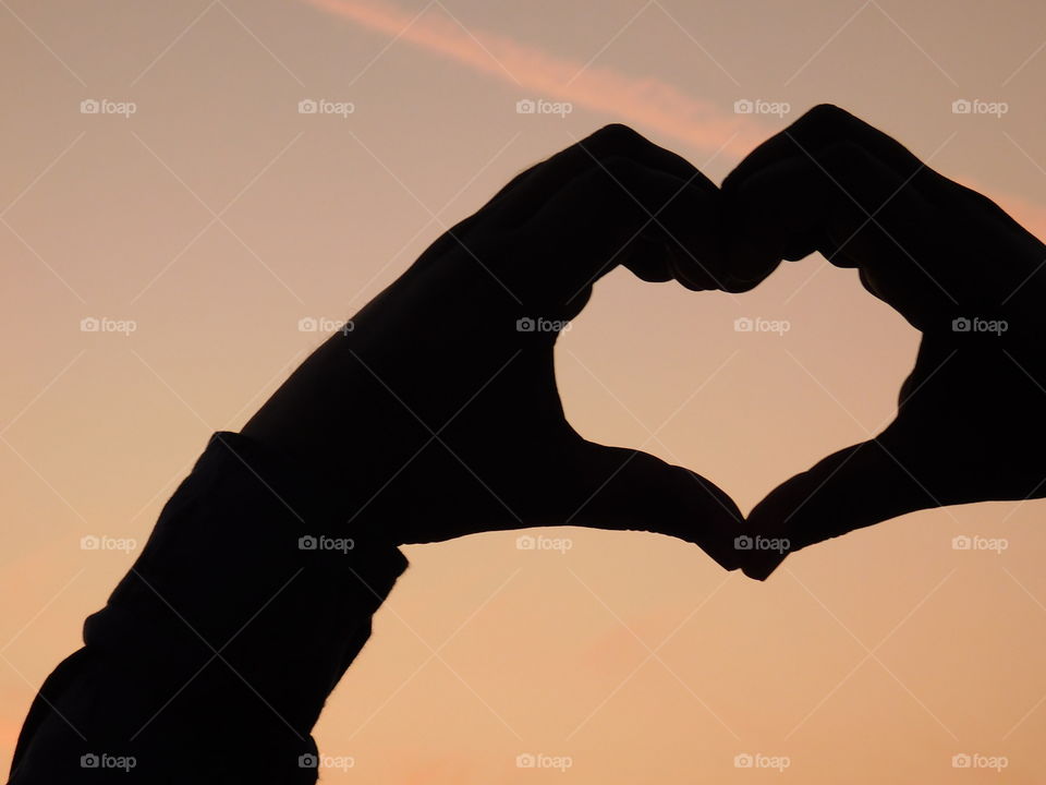 Love wallpaper or heart shaped hand posture with beautiful background.