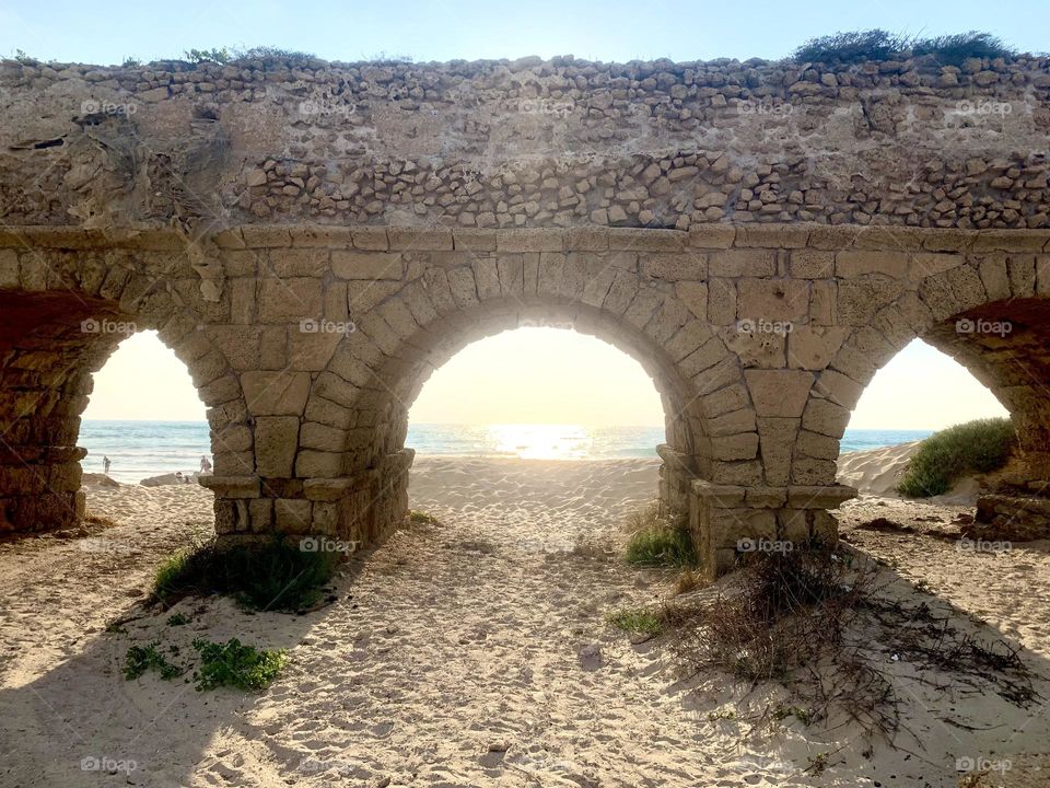 Old aqueduct beach view from the stone arches 