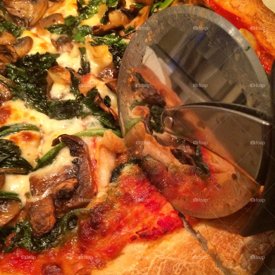 Cutting Pizza. Pizza wheel reflection 