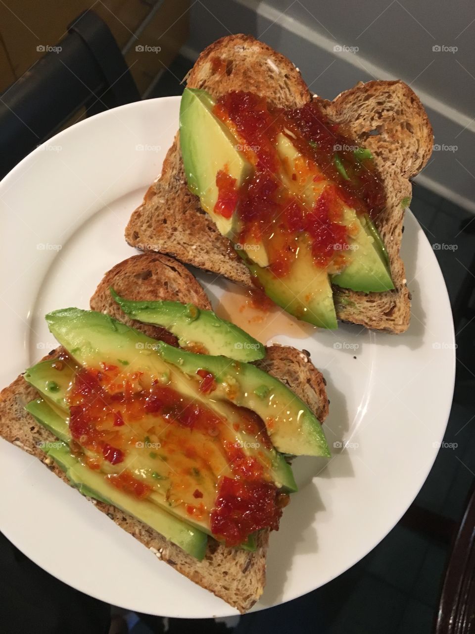 Sprouted grain whole wheat toast with sliced avocado and red pepper jelly. 