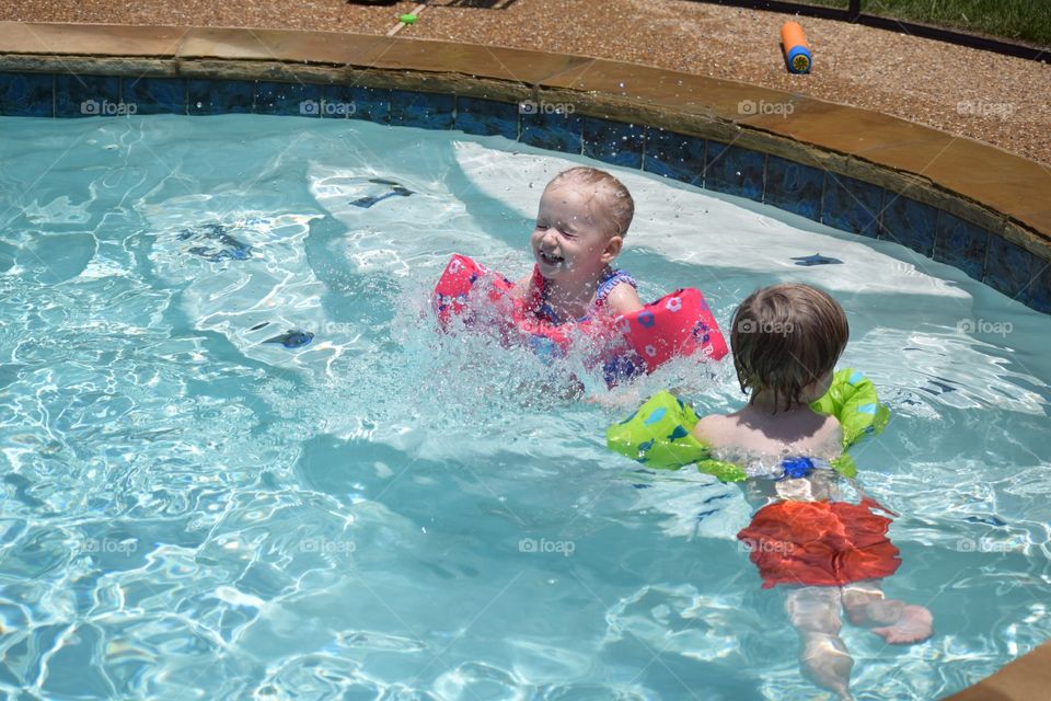 Twins playing in the swimming pool