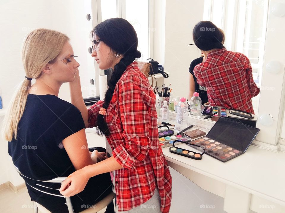 Makeup artist doing makeup for girl