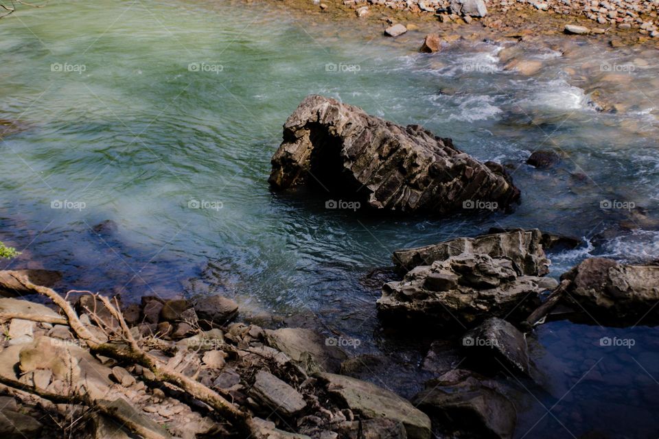 large rock sticking out of the river