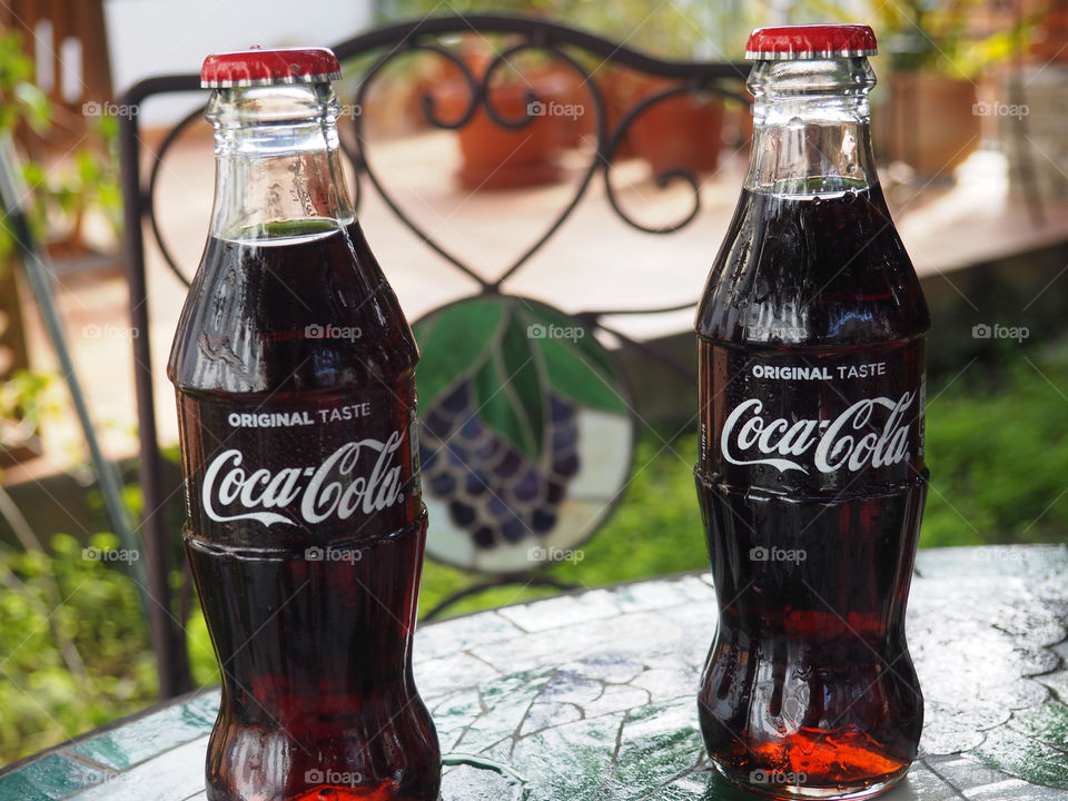 Coca Cola bottles on garden table.