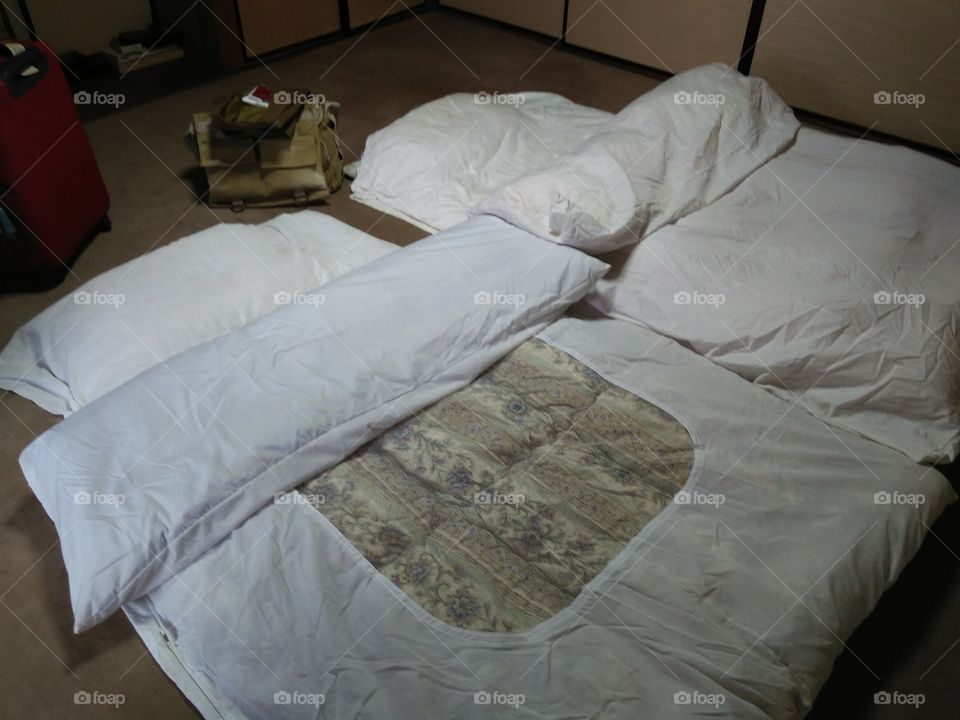 Japanese bedroom style on wooden floor. a comfortable  of white bed matras and blanket