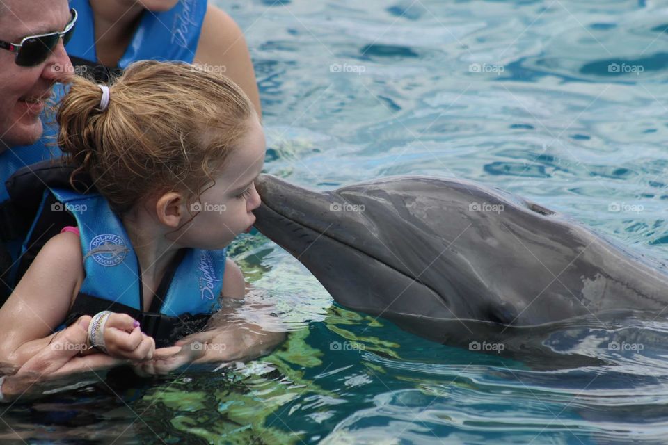 Girl kissing dolphin