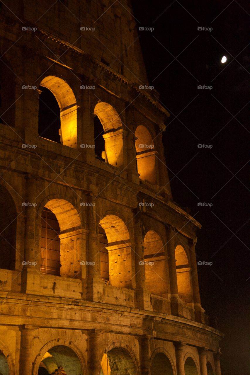 the colosseum in Rome at night with moon