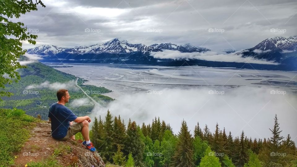 Rear view of man sitting on hill