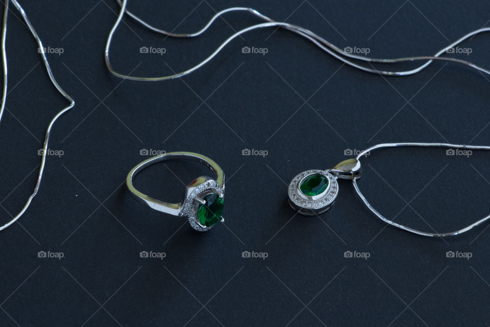 A ring and a necklace with a green color gemstone