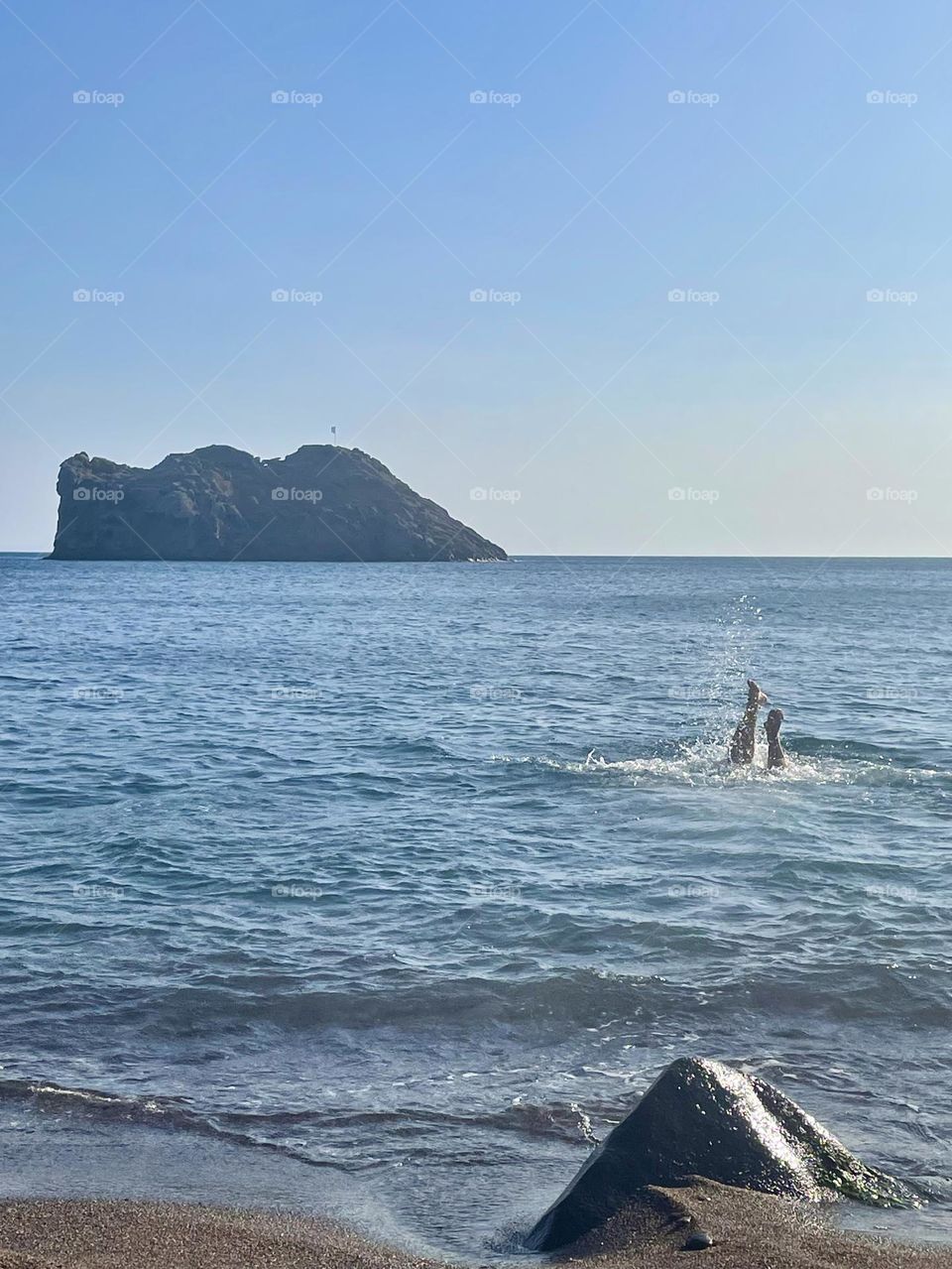 Summer dive in the blue Aegean Sea, sunny beach on Greek island