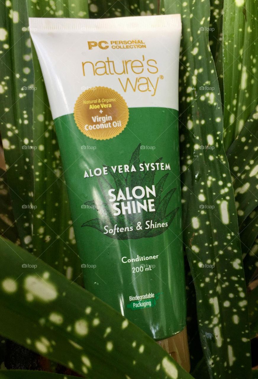 Hair conditioner with green dotted plants on the background 