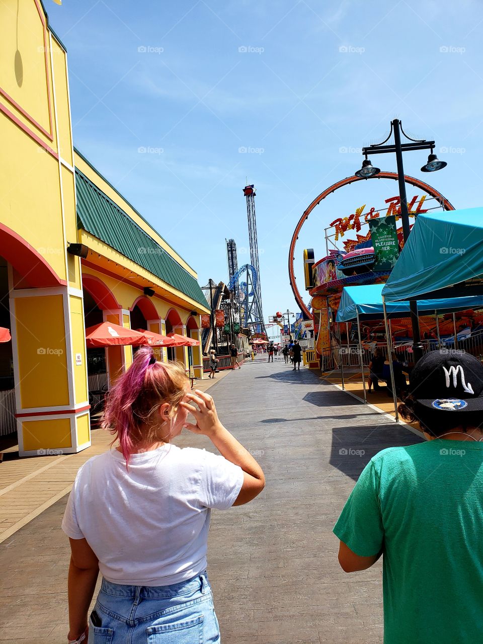 My fiance and my sister walking side by side down the beautifully sunlit walkway of Pleasure Pier.