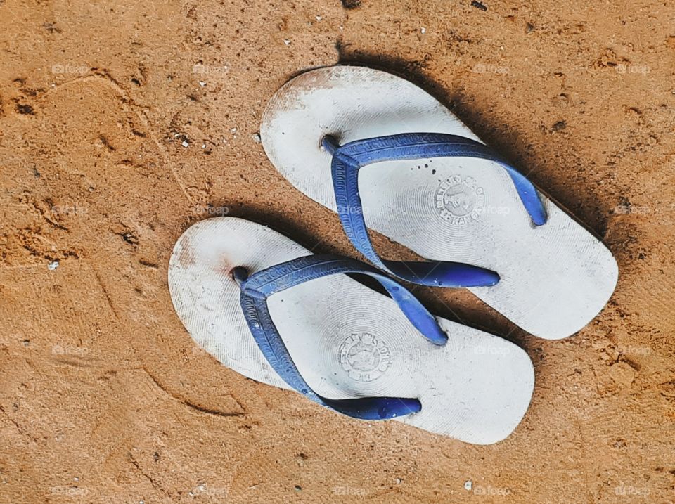 Blue and white sandal on the beach