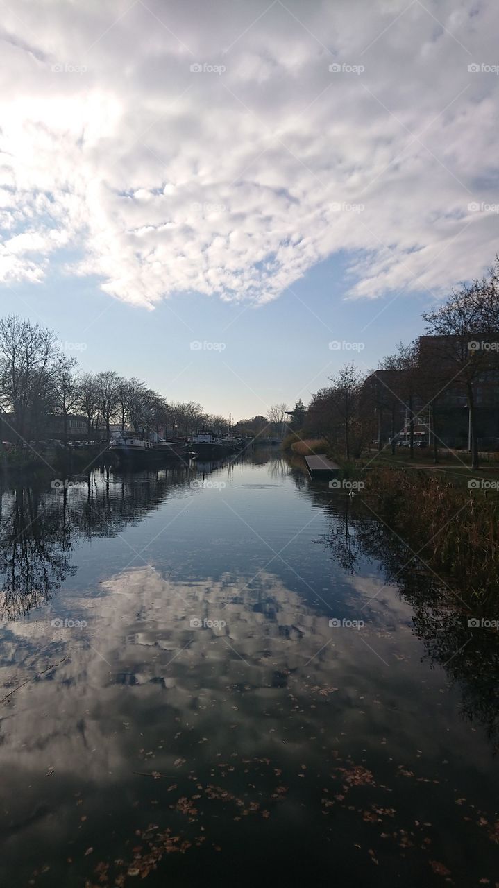 The reflection on this water is beautiful. Surrounded by autumn trees and a bluq sky.