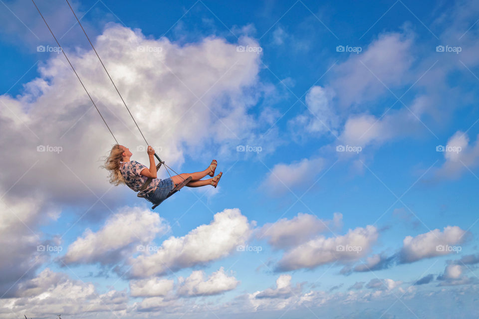 Girl on a swing in the sky