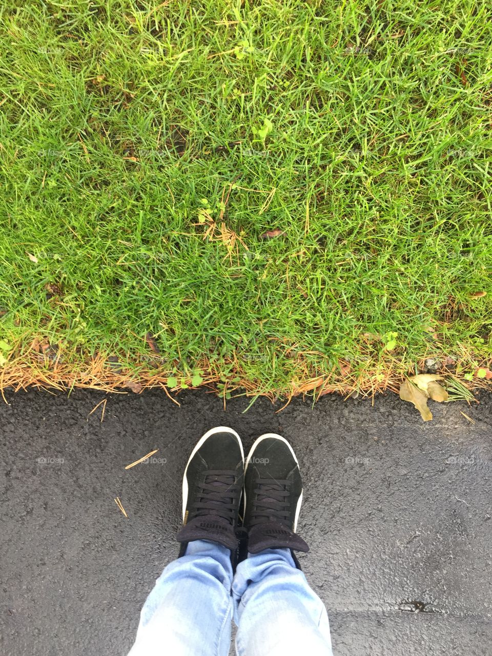 Standing on asphalt near grass