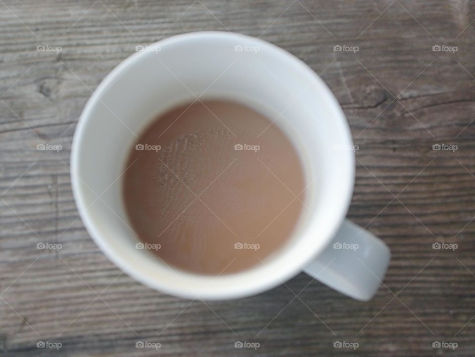 half cup of coffee late on top of wooden table
