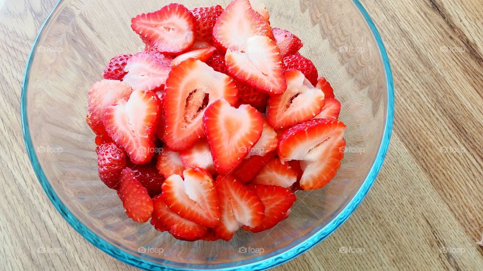 Sliced strawberries in glass bowl; nature's heart-shaped candy