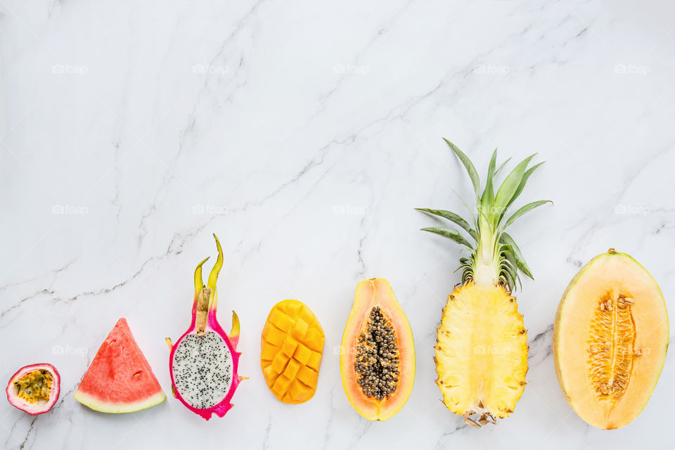 Fresh exotic fruits lying on marble background 