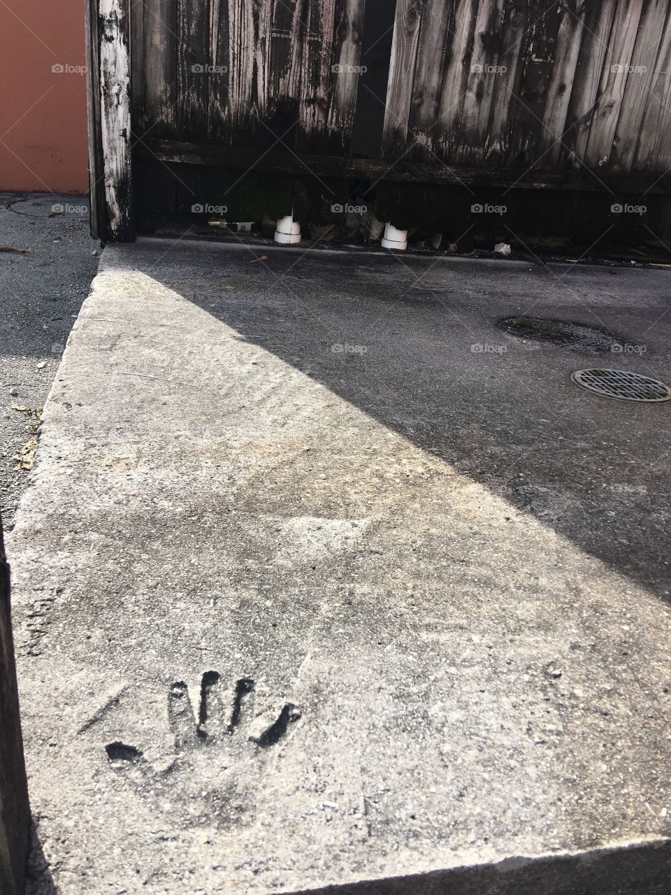 Pressed handprint in cement on alley street  