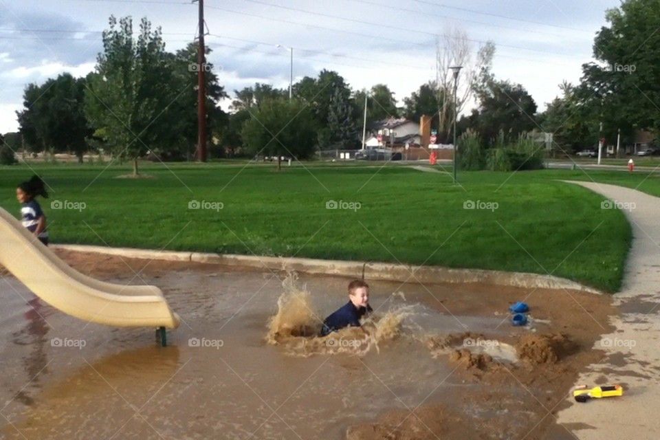 Kid falls in puddle