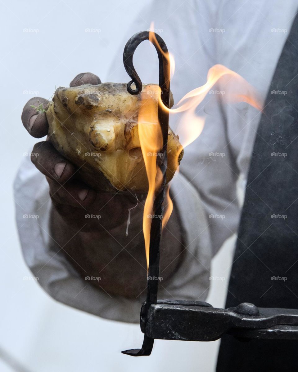 Blacksmith putting coat of beeswax on metal