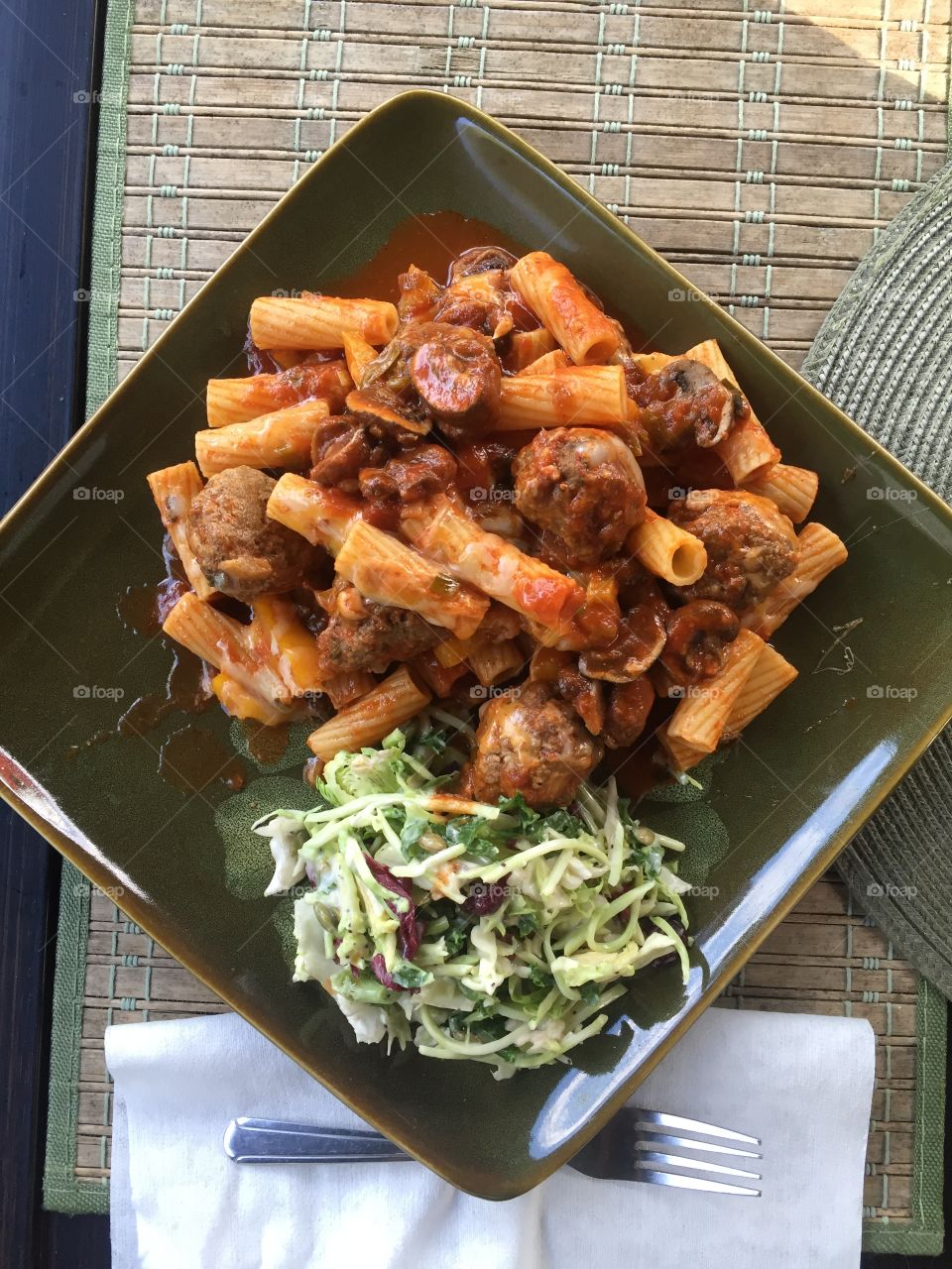 Meatballs in a red sauce with green onions mushrooms and yellow bell pepper