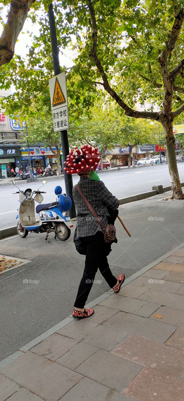 A woman walking, selling sugar-coated haws during the  chinese mid autumn festival