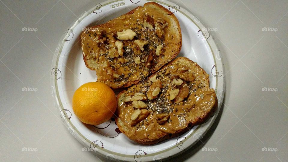 Toast with peanut butter, Chia seeds, and walnuts and an orange