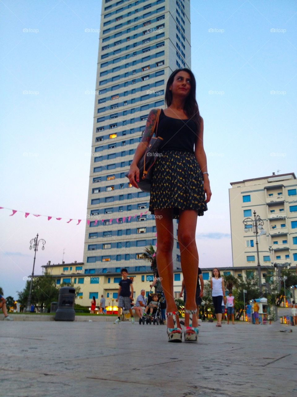 Tall girl. Tall girl in front of a skyscraper in Cesenatico,Italy