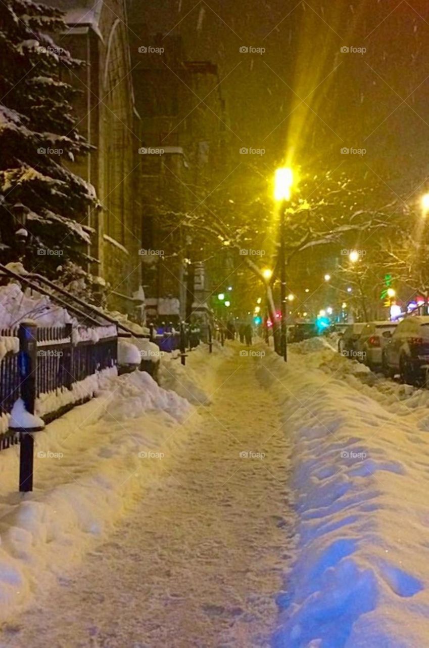 beautiful snowy street under yellow lights 