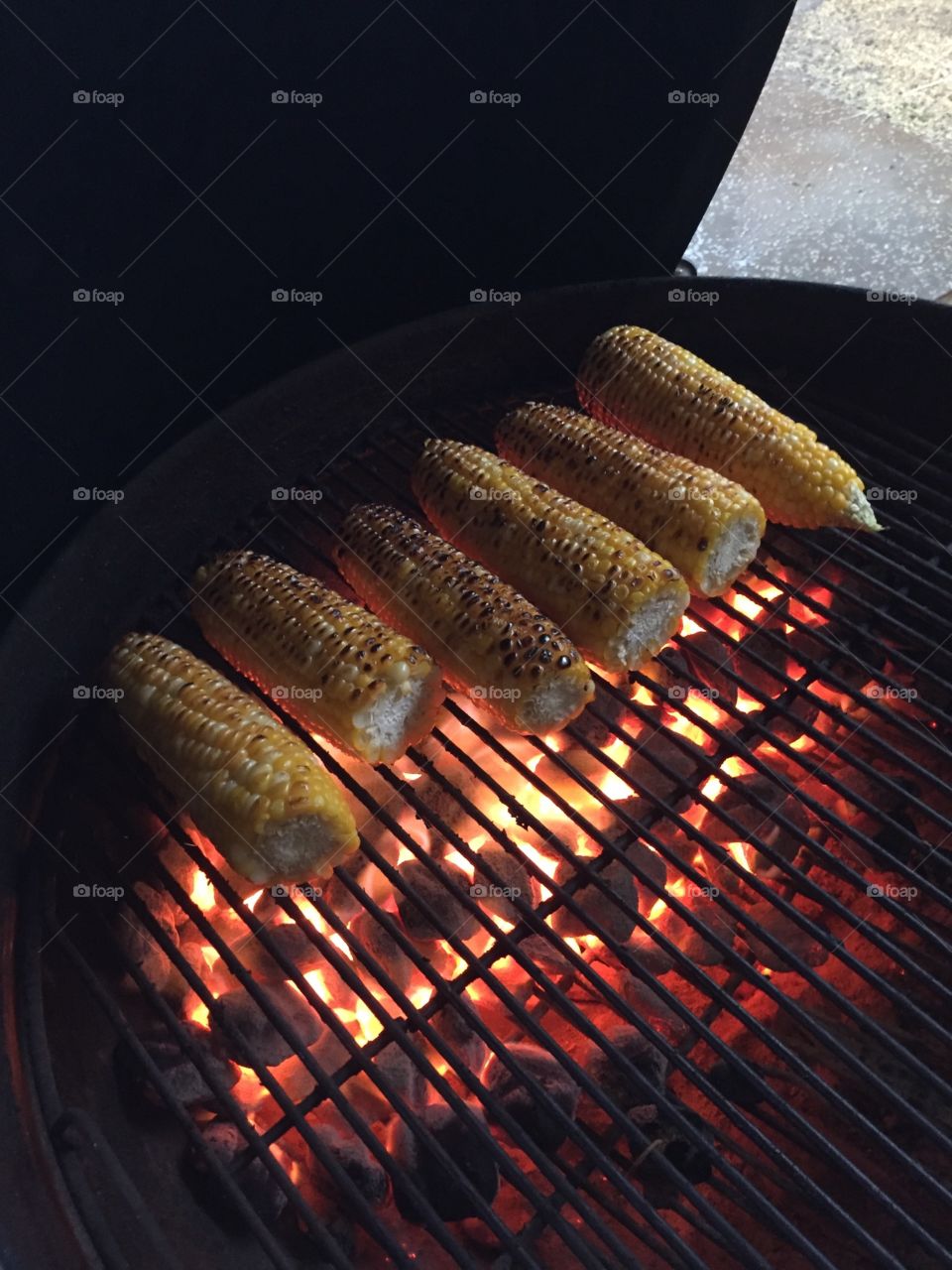 Charcoal embers with corn grilling.