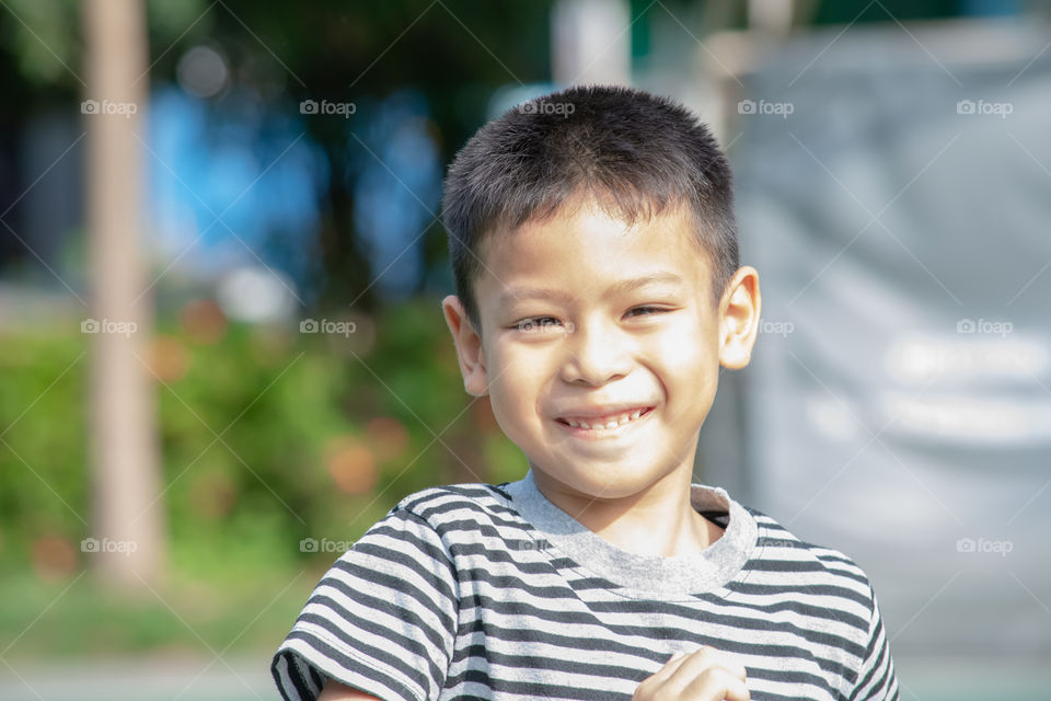 Portrait of a boy Asia, laughing and smiling happily in the park.