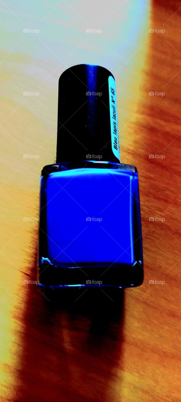 Bote de esmalte de uñas azul luces y sombras naranjas colores complementarios