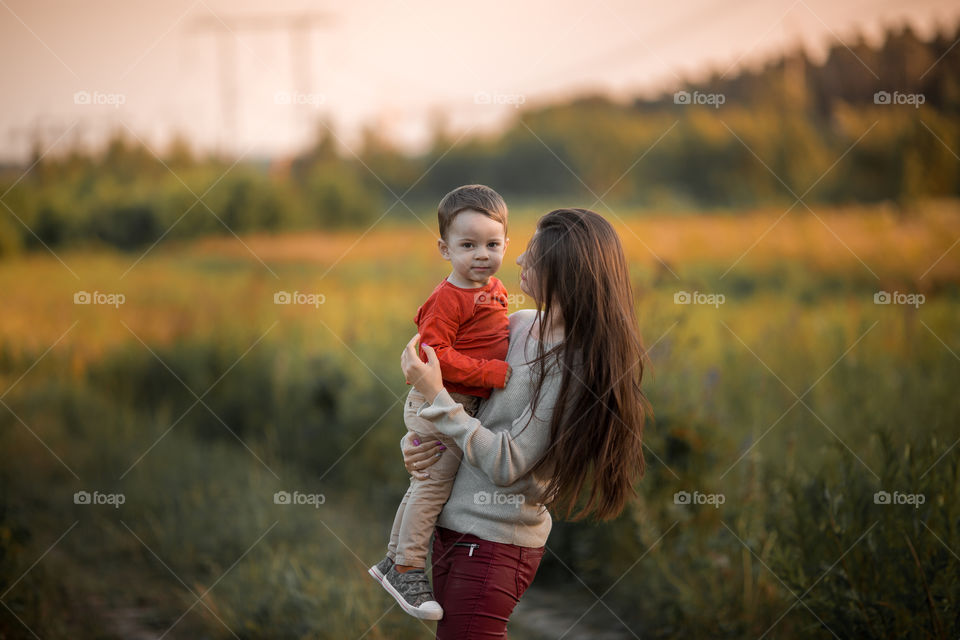 Mother and son with wooden plane at sunset