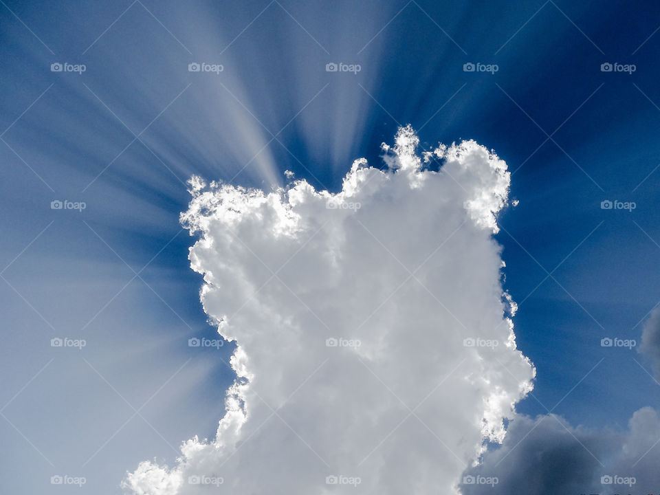 Light fanning out from behind a cloud in an afternoon sky creating a wonderful visual