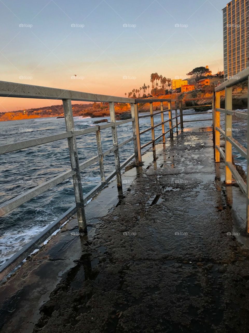 A Pier with the water washing over It during the sun setting!