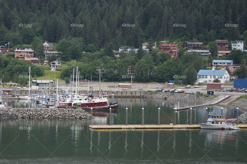 Boats moored or in slips at harbor of Alaskan seaside town.  Boats are a major mode of transportation in Alaska.