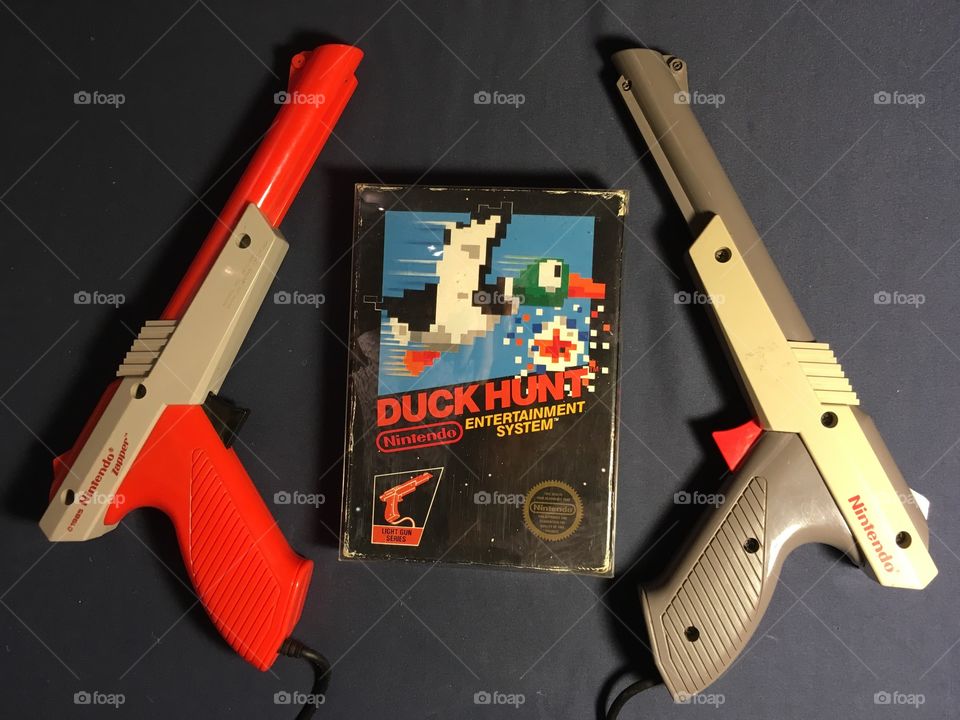 Duck Hunt with Both Nintendo NES Zapper Guns 

Duck Hunt released - 1985
Grey Zapper came before the Orange. Both released 1985