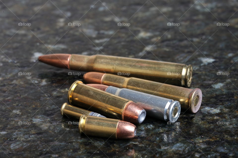 Several bullets. This is a photograph of several caliber of bullets on a granite table.